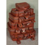 Six vintage leather suitcases.