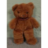 A large plush teddy bear, with tartan bow tie. 82cm tall.