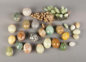 A box of hardstone eggs of varying sizes along with hardstone bunch of grapes. To include onyx