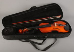 A cased violin with bow. The violin having a one piece 14 inch back.