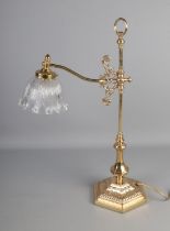 A brass desk lamp with frilled glass shade.