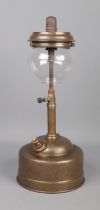 A brass Tilley oil lamp featuring glass shade and 'pork-pie' base.