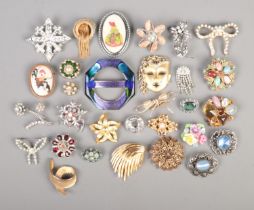 Thirty costume jewellery brooches, to include mask, bow, shell and octagonal examples. Stones