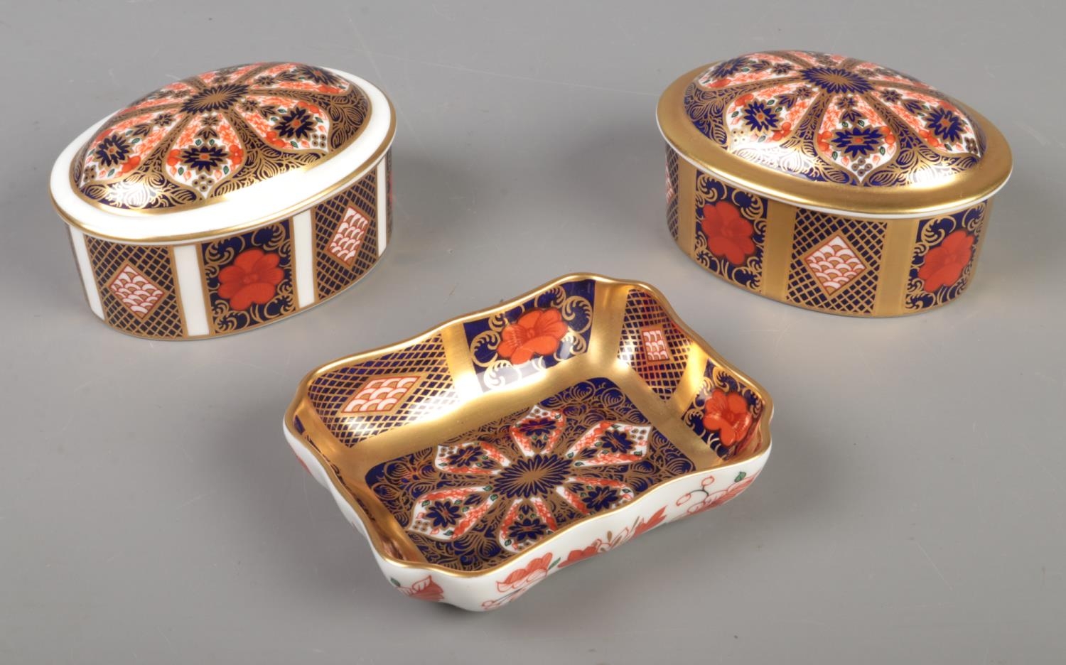 A Royal Crown Derby 1128 imari pattern trinket dish with two trinket boxes of the same pattern.