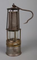A vintage davy-type miners lamp with swing handle. Original marks have worn away.