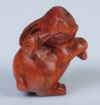 A Japanese carved Netsuke in the form of a rabbit with ruyi.