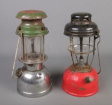 Two Tilley lamps including red coloured example.