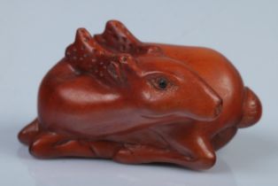 A Japanese carved Netsuke in the form of a resting deer
