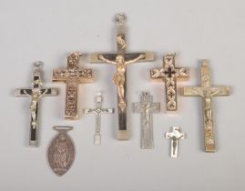 A collection of assorted crucifix pendants and church fobs, including mother of pearl and Italian