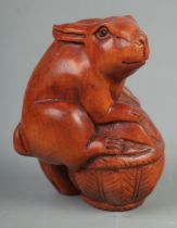 A Japanese carved Netsuke in the form of a rabbit on basket