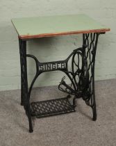 A cast iron singer sewing machine base with wooden top