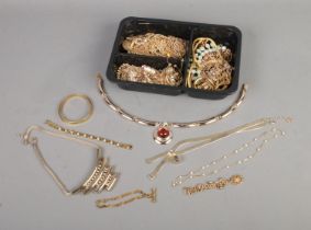 A tray of yellow metal jewellery to include articulated fish charm, necklaces, bangles, etc.