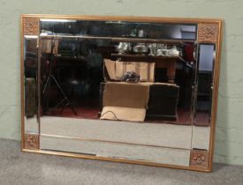 A large decorative gilt framed bevel edge wall mirror. 85cm x 114cm.