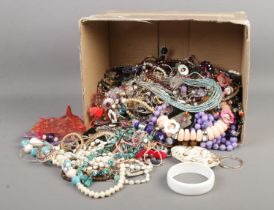 A box of assorted costume jewellery to include beaded necklaces, bangles, bracelets, etc.