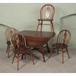 A Ercol elm and beech drop leaf table and four chairs