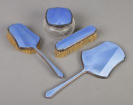 An Art Deco four part silver and guilloche enamel dressing table set. Includes two brushes, hand