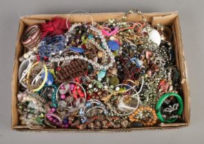 A box of assorted costume jewellery to include beaded necklaces, bangles, leather bracelets,