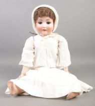 A Schoenau & Hoffmeister bisque head doll, with marks to the back of the neck; 1909, 6, Germany.