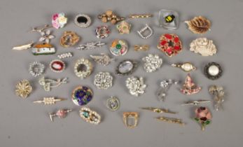 A collection of over 40 costume jewellery brooches to include rose, flag, leaf and bumblebee