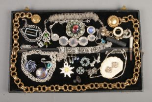 A black box containing vintage costume jewellery, including Butler and Wilson belt, large