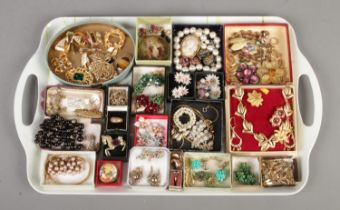 A tray of vintage costume jewellery, including clip on earrings, brooches, pendants, and necklaces.