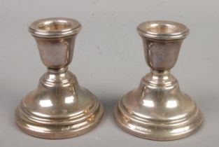 A pair of silver dwarf candlesticks. Assayed Birmingham 1962 by Sanders & Mackenzie. Height 7cm.