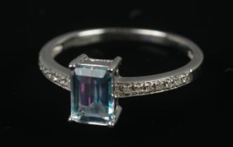 A 9ct white gold ring set with central blue topaz and diamond shoulders. Size N, 2.15g. One