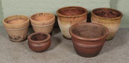 Six terracotta garden planters to include two pairs with one featuring engraved floral border.