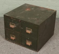 A green metal bank of four drawers with small contents of tools.