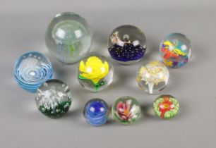 A collection of ten glass paperweights to include Alum Bay Glass and Mdina examples.