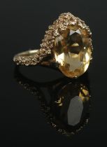 A 9ct Gold dress ring, with large citrine coloured stone set within a decorative mount. Size K.