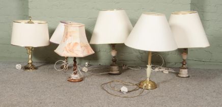 A collection of assorted lamps to include marble and turned wooden examples.