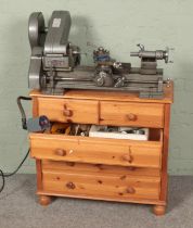 A Myford ML10 Lathe on pine chest of drawers with multiple accessories.