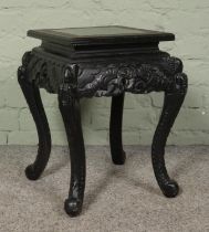 An Oriental lacquered jardiniere stand with Greek Key border, carved detailing and cabriole feet.