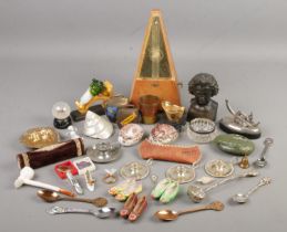 A box of collectables. Includes silver rim jar, metronome, oriental shells, souvenir spoons, gilt