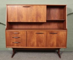 A vintage teak AustinSuite highboard. Having drop down cupboard top and drawer and cupboard base.