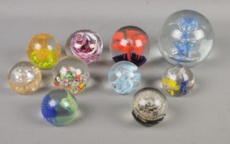 A collection of ten paperweights of varying sizes to include Caithness Weaver 2005 and examples