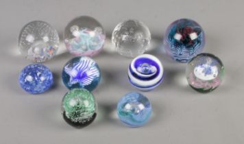 A collection of ten glass paperweights to include Milliennium globe, Caithness and Selkirk glass