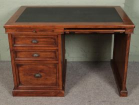 A stained pine kneehole desk with leather inset top.