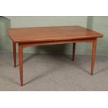 A Danish Gudme Mobelfabrik teak drawer leaf dining table raised on tapering supports. Stamped