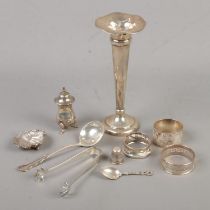 A quantity of silver items. Includes trumpet vase, pepperette, napkin rings, thimble, spoons, salt