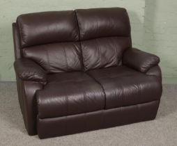 Two brown leather two seater sofas along with a complete leather sofa care kit.