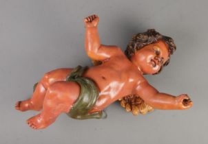 A large painted plaster wall hanging model of a cherub. Approx. length 53cm. Possibly missing bugle.