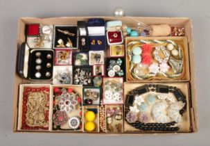 A card tray containing a variety of vintage jewellery, including hat pins, clip on earrings,