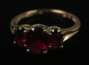 A 9ct gold three stone ruby ring. Size L, 2.18g.