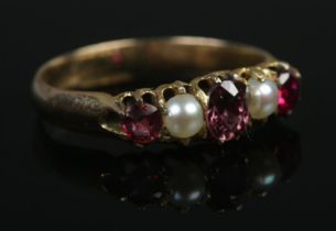 A 9ct Gold five stone ring, featuring ruby coloured stones. Size JÂ½. Total weight: 1.8g.