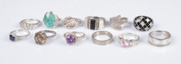 A collection of eleven silver rings to include eternity and mother of pearl examples. Total weight