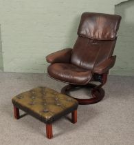 An Ekornes Stressless brown leather reclining armchair along with a green leather buttoned