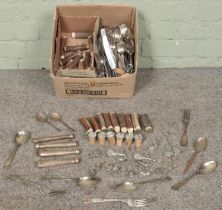 A box of cutlery, metal mounted corks and keyrings. Includes horn handles, pair of silver spoons,