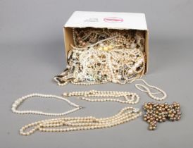 A box containing a good collection of simulated pearls to include single silver clasped example.